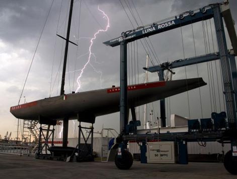 America's Cup boats are lifted out of the water during the night